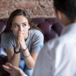 Young woman visiting therapist counselor.