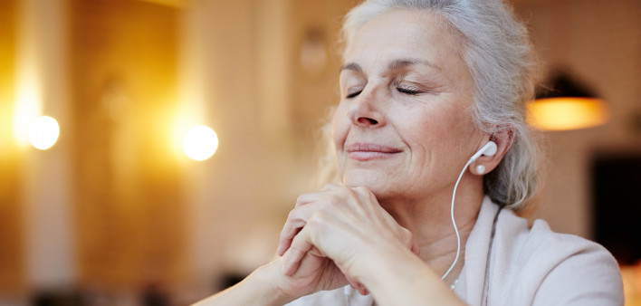 Mature woman with earphones listening to music