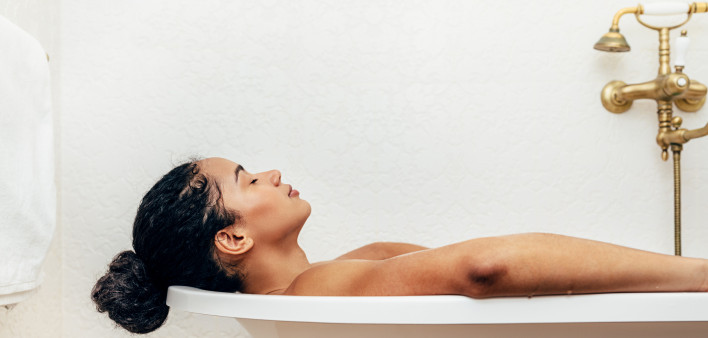 Side view of young woman having a bath