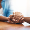 Closeup shot of two unrecognizable people holding hands in comfort at home