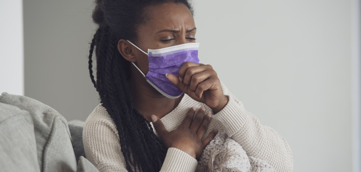 woman with mask coughing