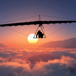 man hang gliding sunset clouds