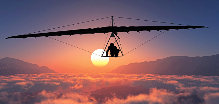 man hang gliding sunset clouds