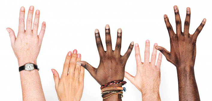 different race hands reaching upward