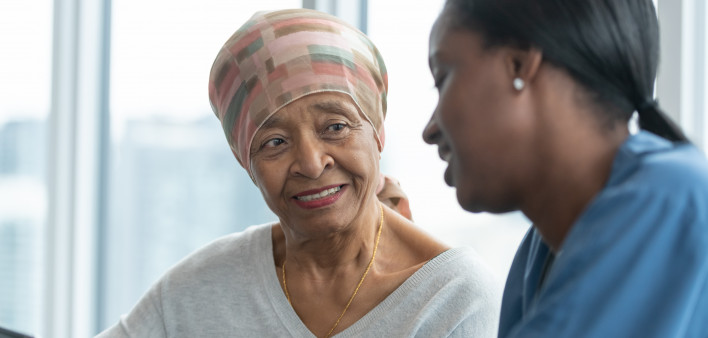 Senior woman with cancer reviews test results with female doctor