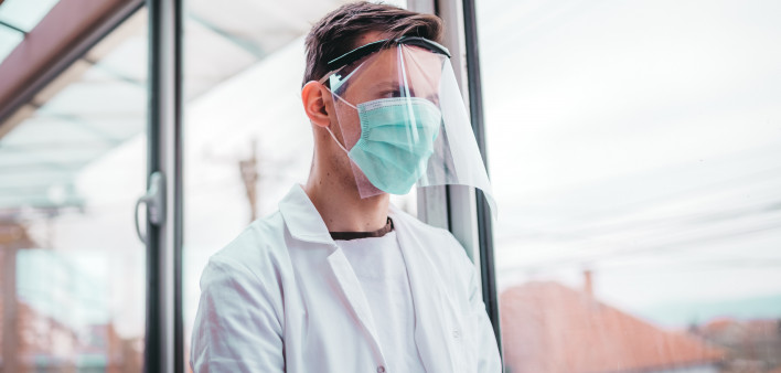 Young doctor with a protective equipment agaist corona virus, wearing a mask and visor