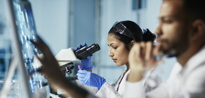 Scientist Working on Computer In Modern Laboratory all graps, dna models,