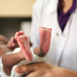 nurse holding baby showing feet