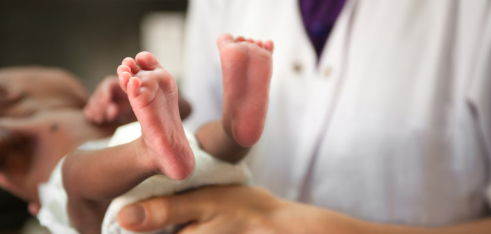 nurse holding baby showing feet