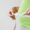 Fat overweight woman measuring her waist.