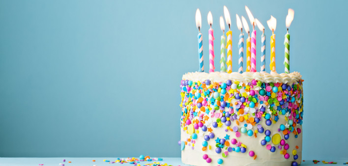 Birthday cake decorated with colorful sprinkles and ten candles