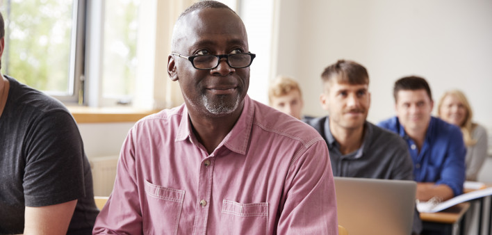 Mature Student Using Digital Tablet In Adult Education Class