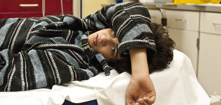 Teenager in a hospital emergency room looking at the camera, could be for overdose, alcohol, depression, accident or any other medical condition