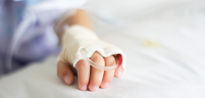 Saline intravenous (iv) drip in a Children's patient hand