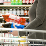 Woman comparing ingredients on soda bottle