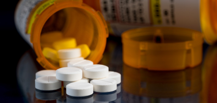 Macro of oxycodone opioid tablets with prescription bottles