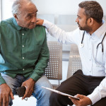 Doctor consoling sad senior male patient