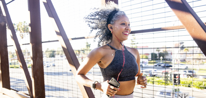 A Black Woman Running on a bridge