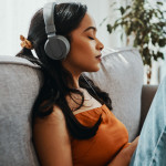 Shot of a young woman using headphones while relaxing on the sofa at home