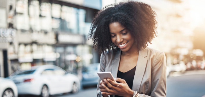 Shot of a young businesswoman using a cellphone in the city