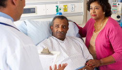 Doctor Talking To Senior Couple On Ward Worried