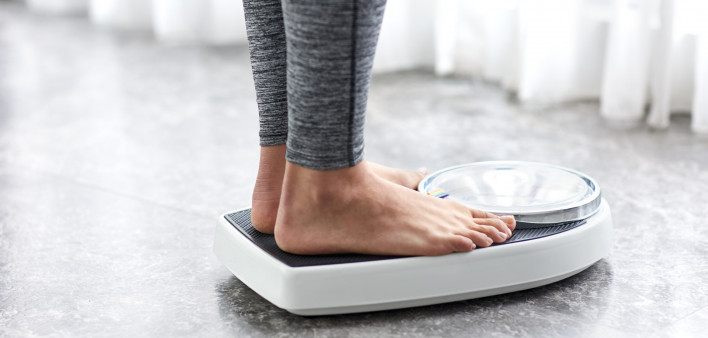Young healthy girl on home scales