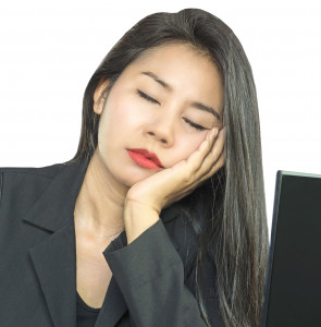 woman sleeping at desk head in hand