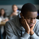 Black guy sit alone in cafe suffering from racial discrimination