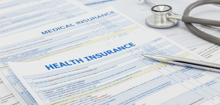 Medical insurance application, silver pen and stethoscope. Legal law contract and health insurance concepts.