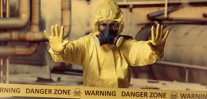 man in protective yellow gear and gas mask danger zone