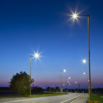 Night empty road with modern LED street lights, entrance to a small