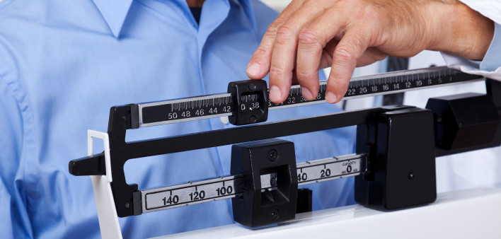 man getting weight checked on scale