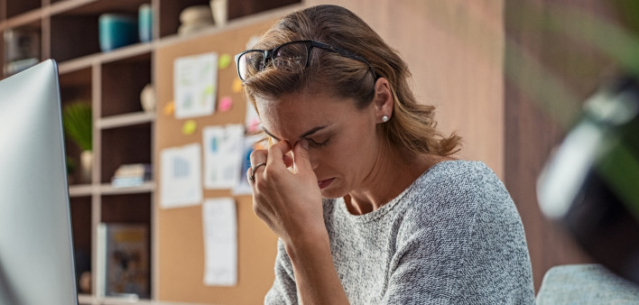 Exhausted businesswoman having a headache in modern office.