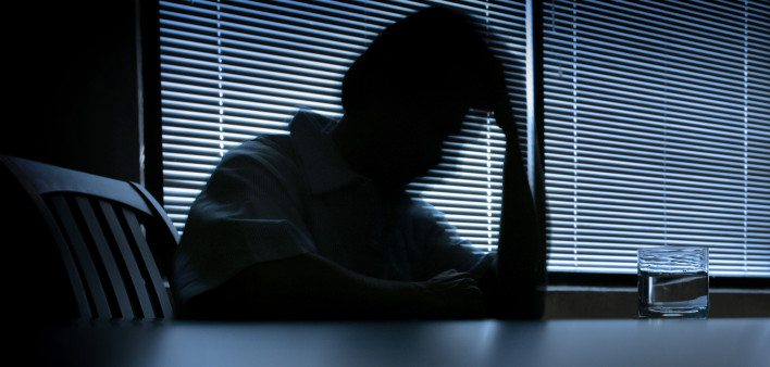 depressed man in a dark room 