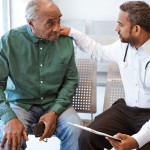 Doctor consoling sad senior male patient