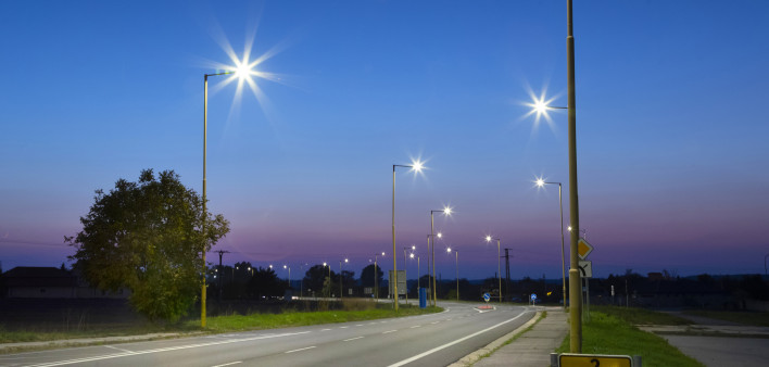 Night empty road with modern LED street lights, entrance to a small