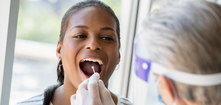 Doctor performing Covid-19 tests on patient while wearing protective gear stock photo