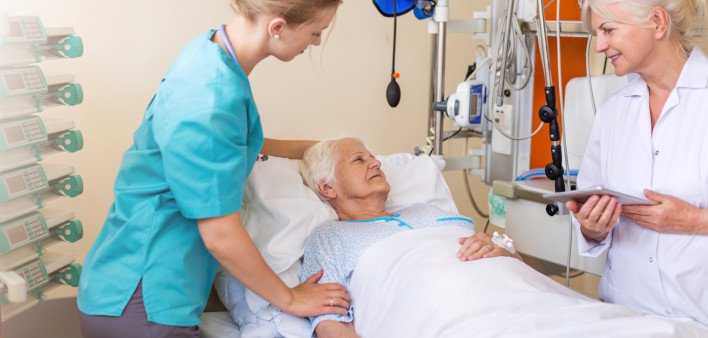 Senior patient in hospital bed nurse