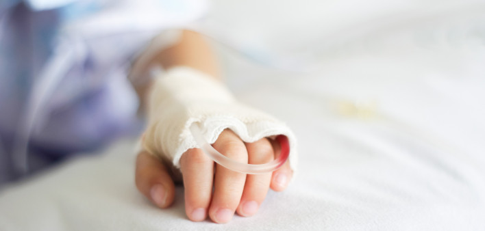Saline intravenous (iv) drip in a Children's patient hand