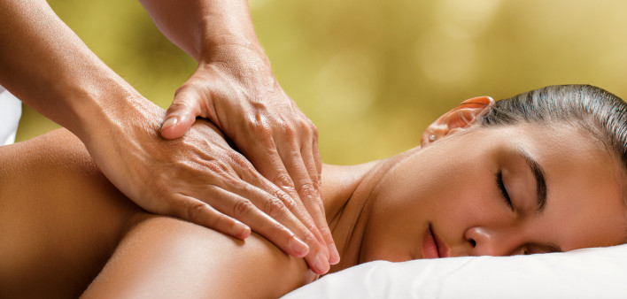 Young woman enjoying massage in spa