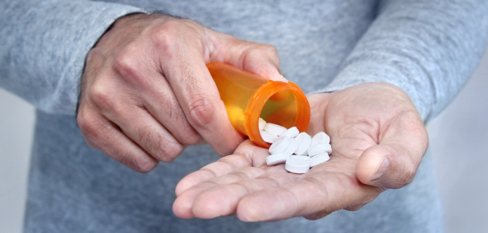 man taking pills pills in his hand