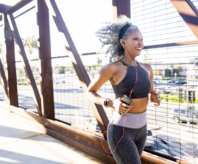 A Black Woman Running on a bridge
