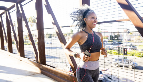 A Black Woman Running on a bridge