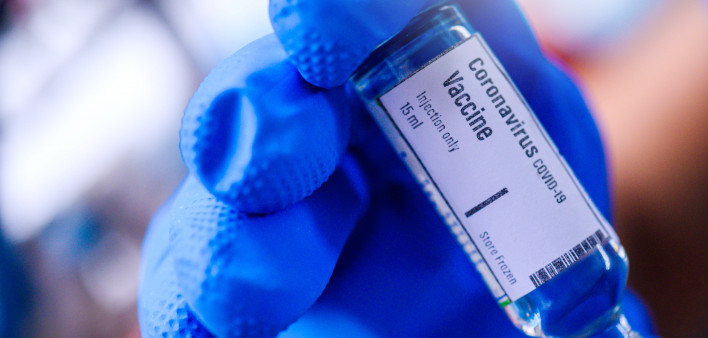 Image of Hand holds Coronavirus Covid-19 Vaccine glass bottle.