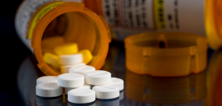 Macro of oxycodone opioid tablets with prescription bottles