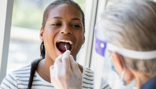 Doctor performing Covid-19 tests on patient while wearing protective gear stock photo