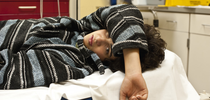 Teenager in a hospital emergency room looking at the camera, could be for overdose, alcohol, depression, accident or any other medical condition