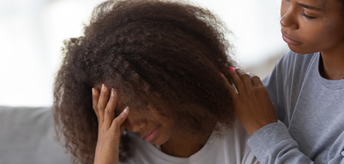Young African American mom hug disappointed sad teenage daughter, caressing and comforting her, black teen girl feel down, suffer from school problems, mommy or nanny embrace and support