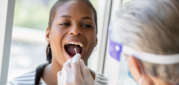 Doctor performing Covid-19 tests on patient while wearing protective gear stock photo