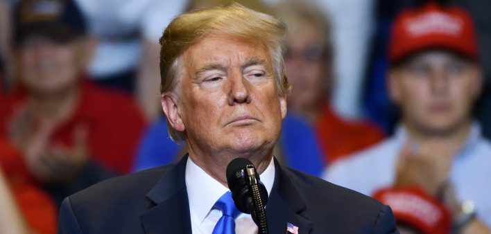President Donald Trump with a serious look as he delivers a speech at a campaign rally held at the Mohegan Sun Arena.